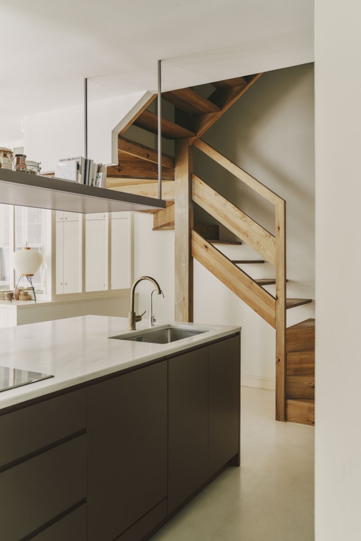 A minimalist pine wood staircase connecting the two levels of the duplex.