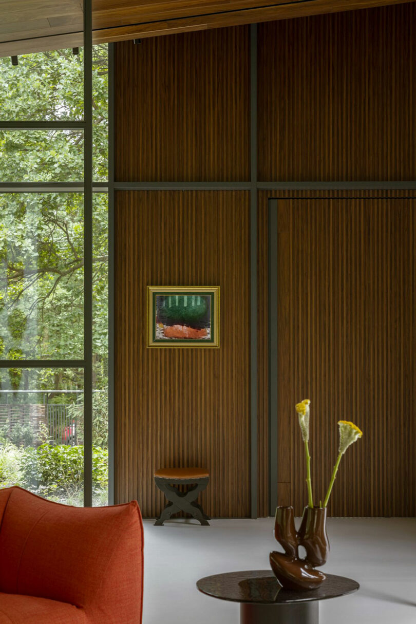 Modern living room featuring wood-paneled walls, stone textures, and a minimalist orange sofa.