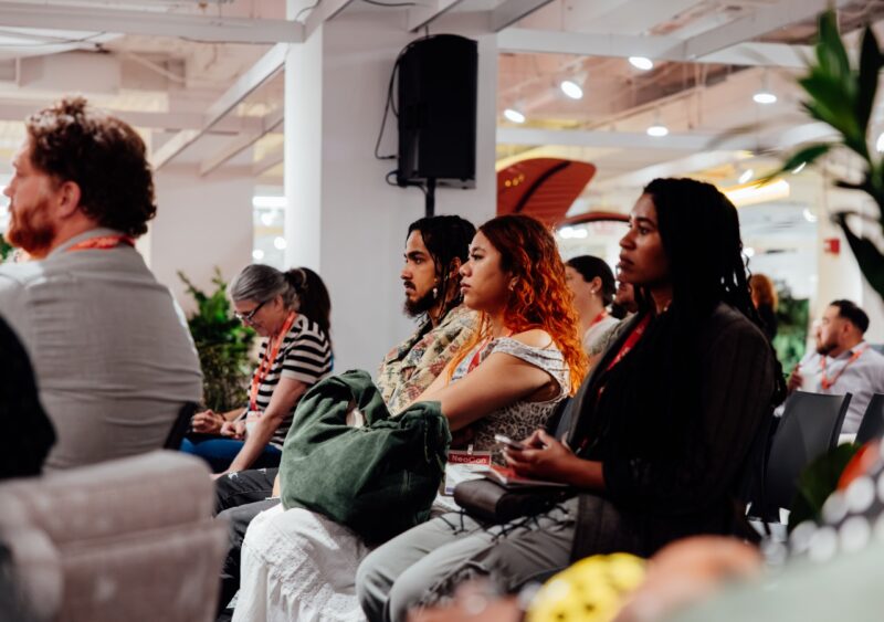 A diverse group of professional attendees focused on a panel discussion at NeoCon.