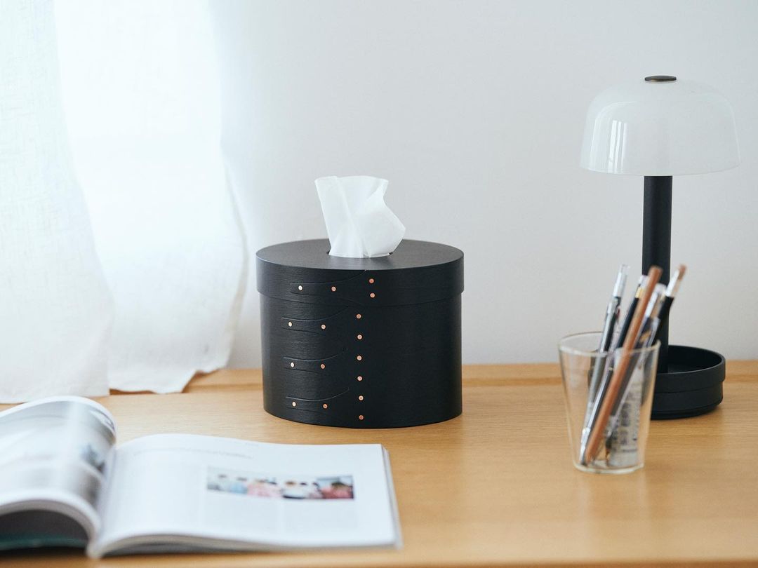 A minimalist cherry wood tissue box holder with copper rivets.