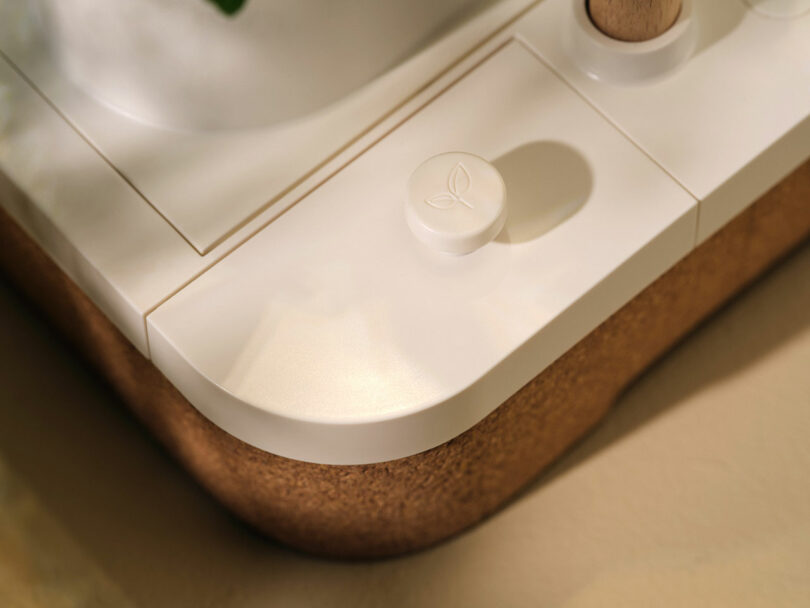 Close-up of a leaf-shaped touch button on the white Auk Mini unit.