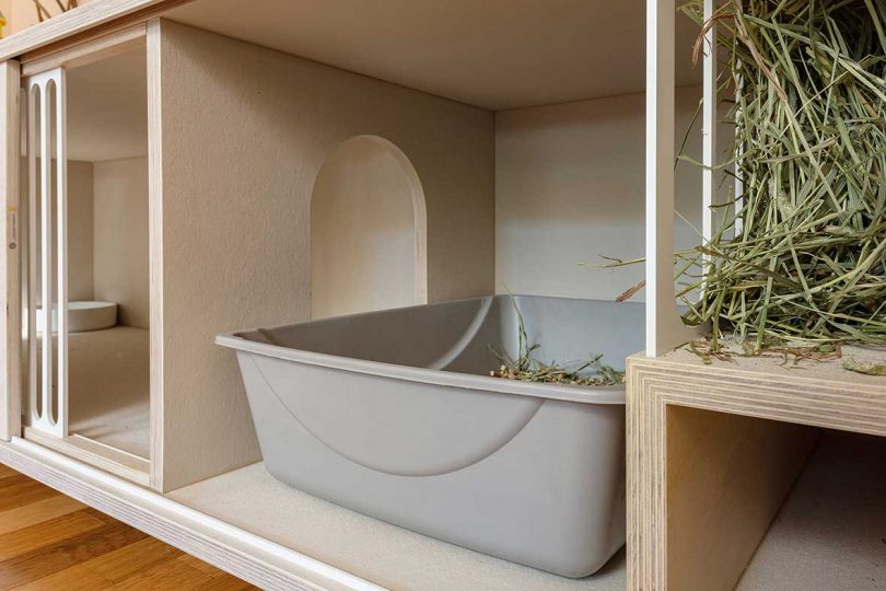 Interior view of a wooden rabbit bench showing a built-in hay feeder and litter box space.