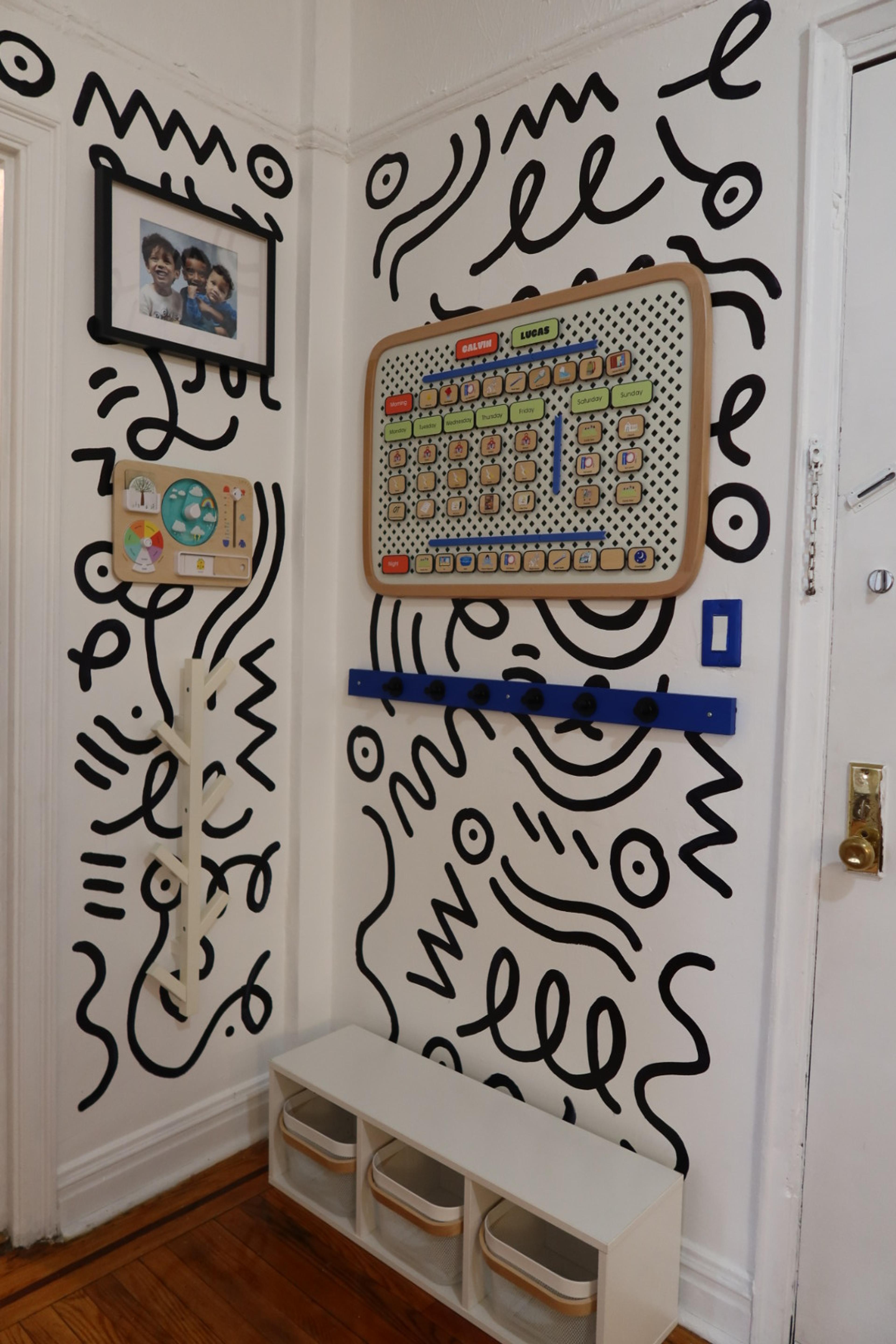 A colorful wall-mounted weekly visual calendar with icons for children's activities.