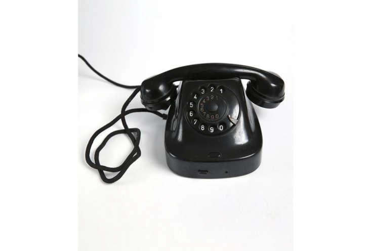 A black vintage rotary telephone.
