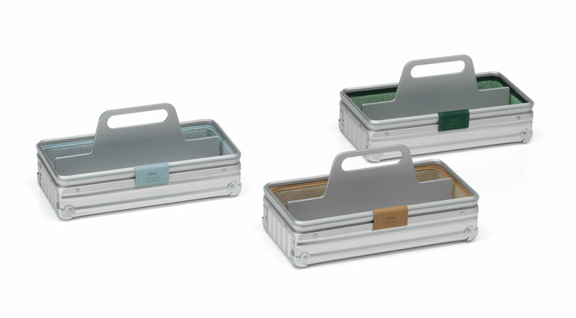 Three silver aluminum toolboxes with handles, featuring mesh liners and color-coded labels in blue, green, and tan.