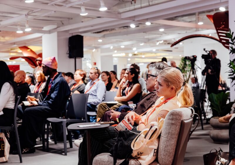 Large audience seated in rows at a NeoCon 2026 presentation.
