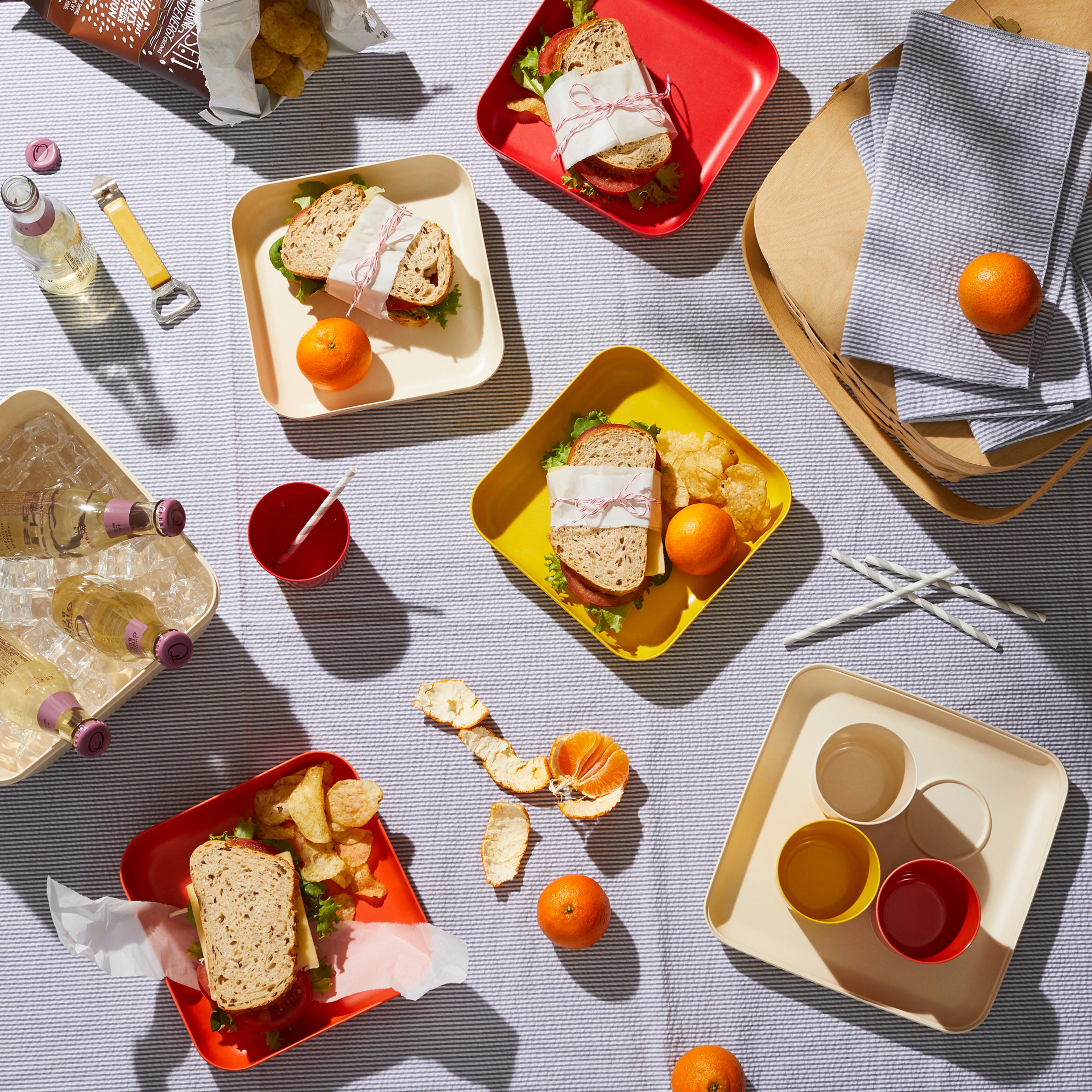 Simple, neatly wrapped sandwiches placed on a picnic blanket.