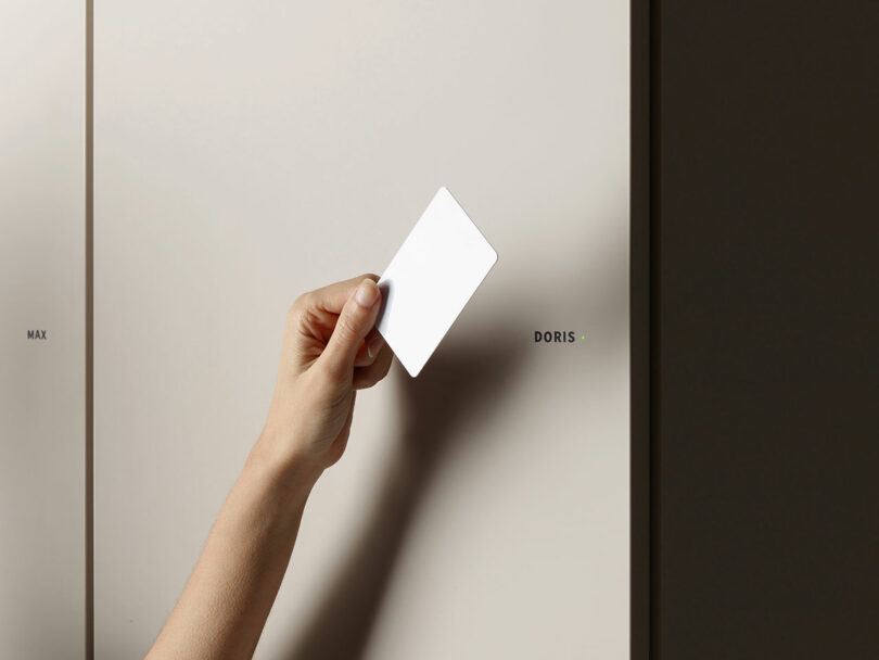 A close-up of a hand using an RFID card to unlock a locker compartment featuring a small green LED indicator.
