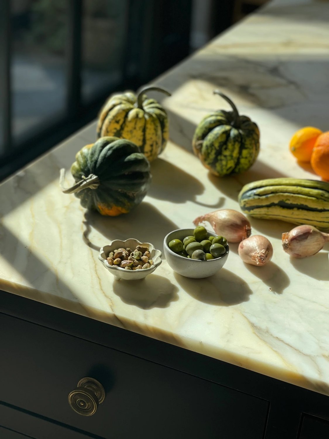 Slicing delicata squash into uniform half-moon shapes on a cutting board.
