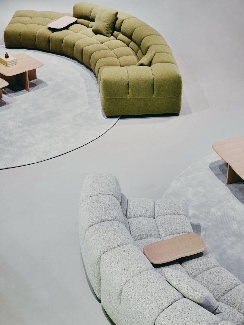 Two curved Tufty-Time 20 sofas in green and light gray arranged in a spacious, sunlit gallery-style room.