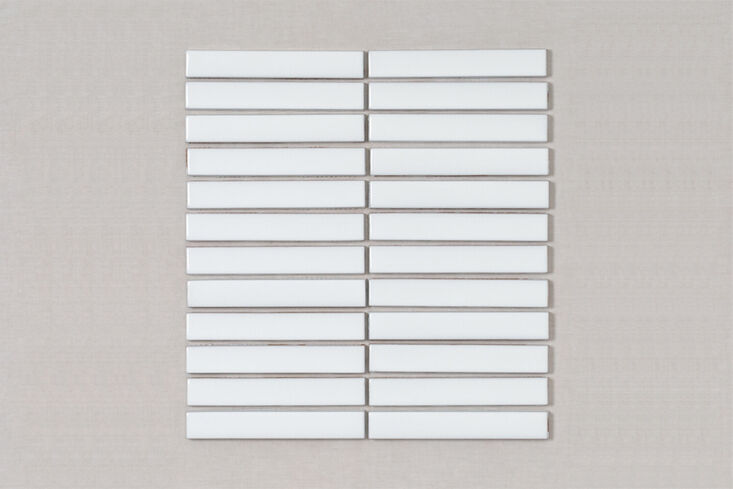Close-up of Fireclay Tile 1x6 sheeted tiles arranged vertically on a bathroom wall.