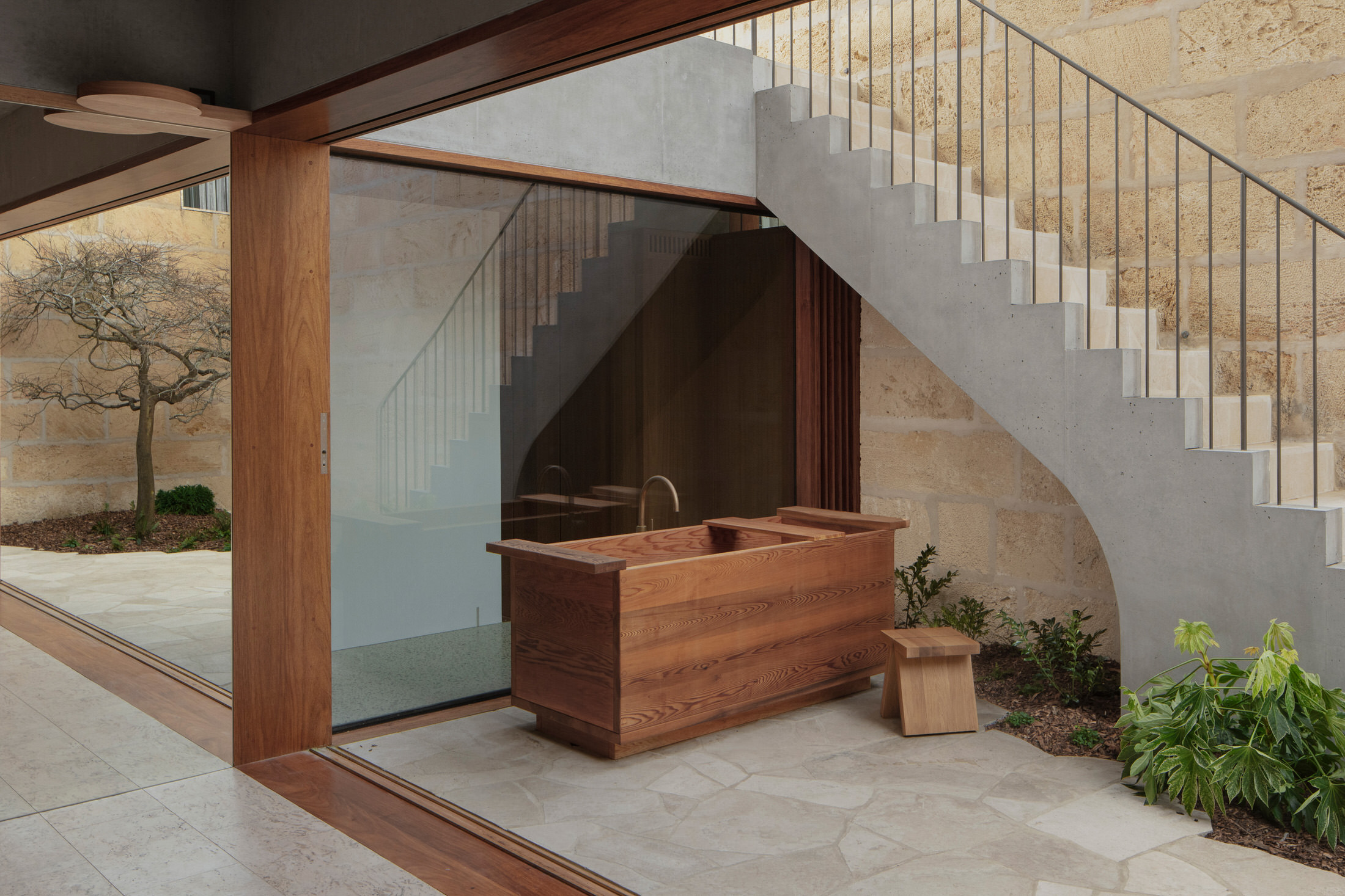 View from the modern kitchen looking out onto the stone-paved courtyard and garden.