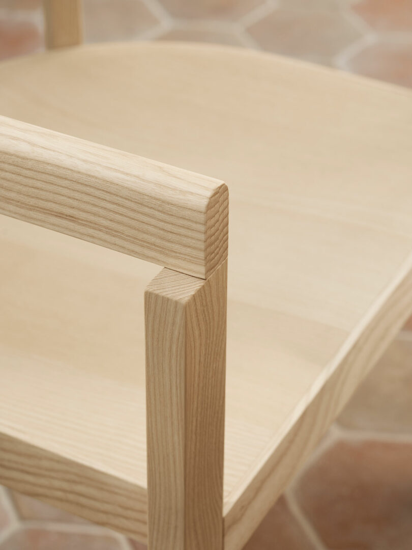 A close-up of the light wood After chair showing the precise joint where the backrest meets the seat.
