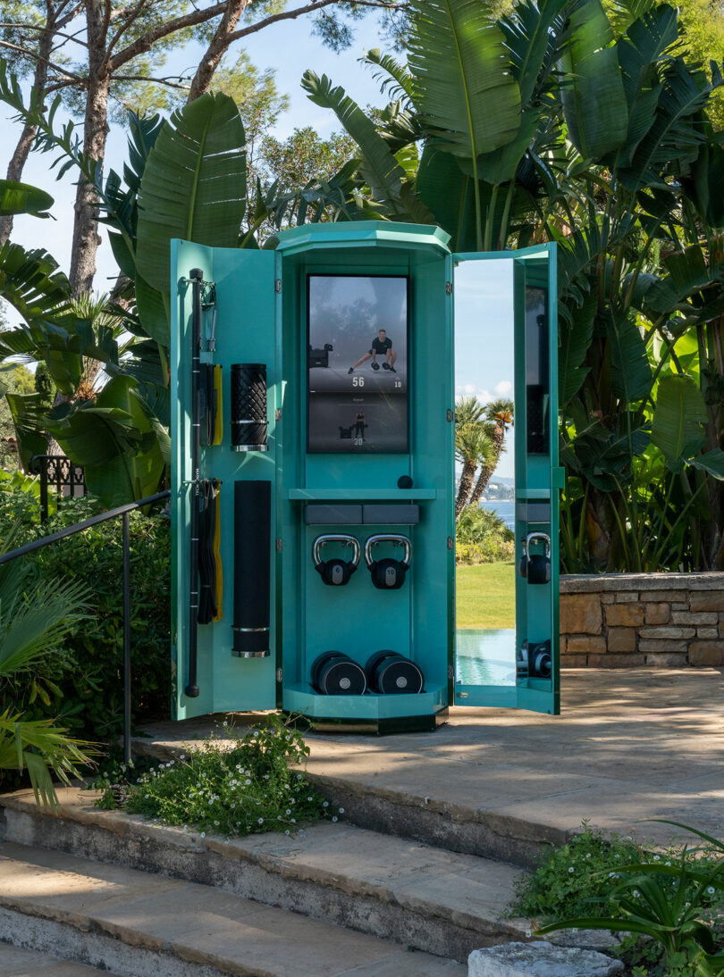 Interior view of the turquoise Ottagono cabinet showing weights and a digital screen.