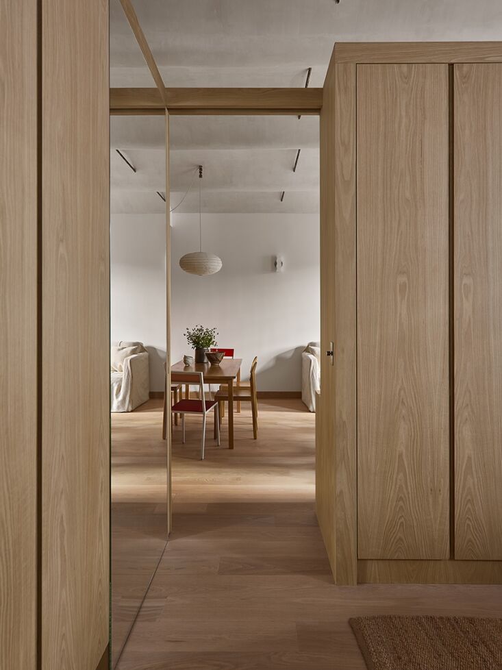 Looking upward from a bedroom toward a dining area, showing a textured barrel-vaulted ceiling and dark metal structural ties.