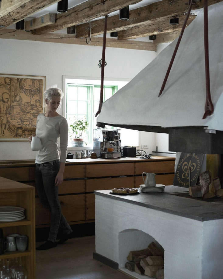 Nadine Redzepi standing in her kitchen next to a traditional wood stove.