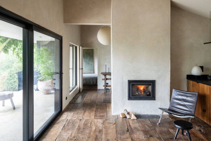 A dual-sided fireplace standing between the main living area and a hallway.