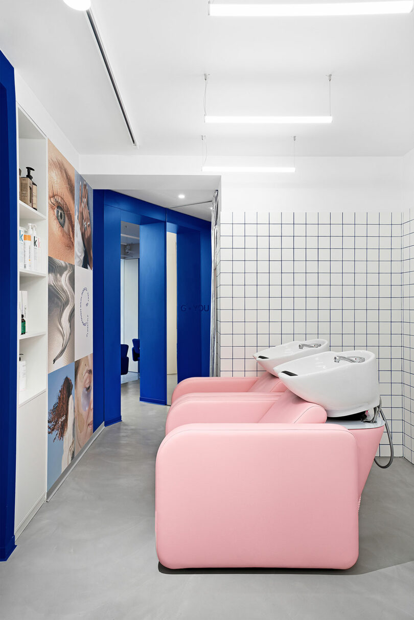 Pink salon hair-washing chairs set against a blue and white patterned tile wall.