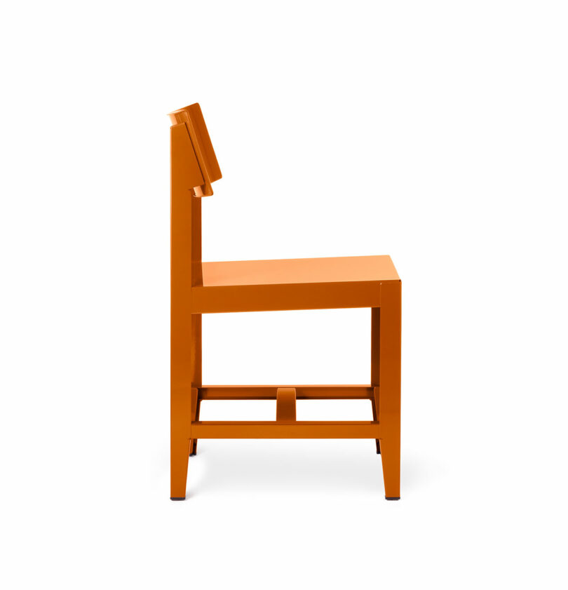Side view of an orange, minimalist chair with straight lines and a flat seat.