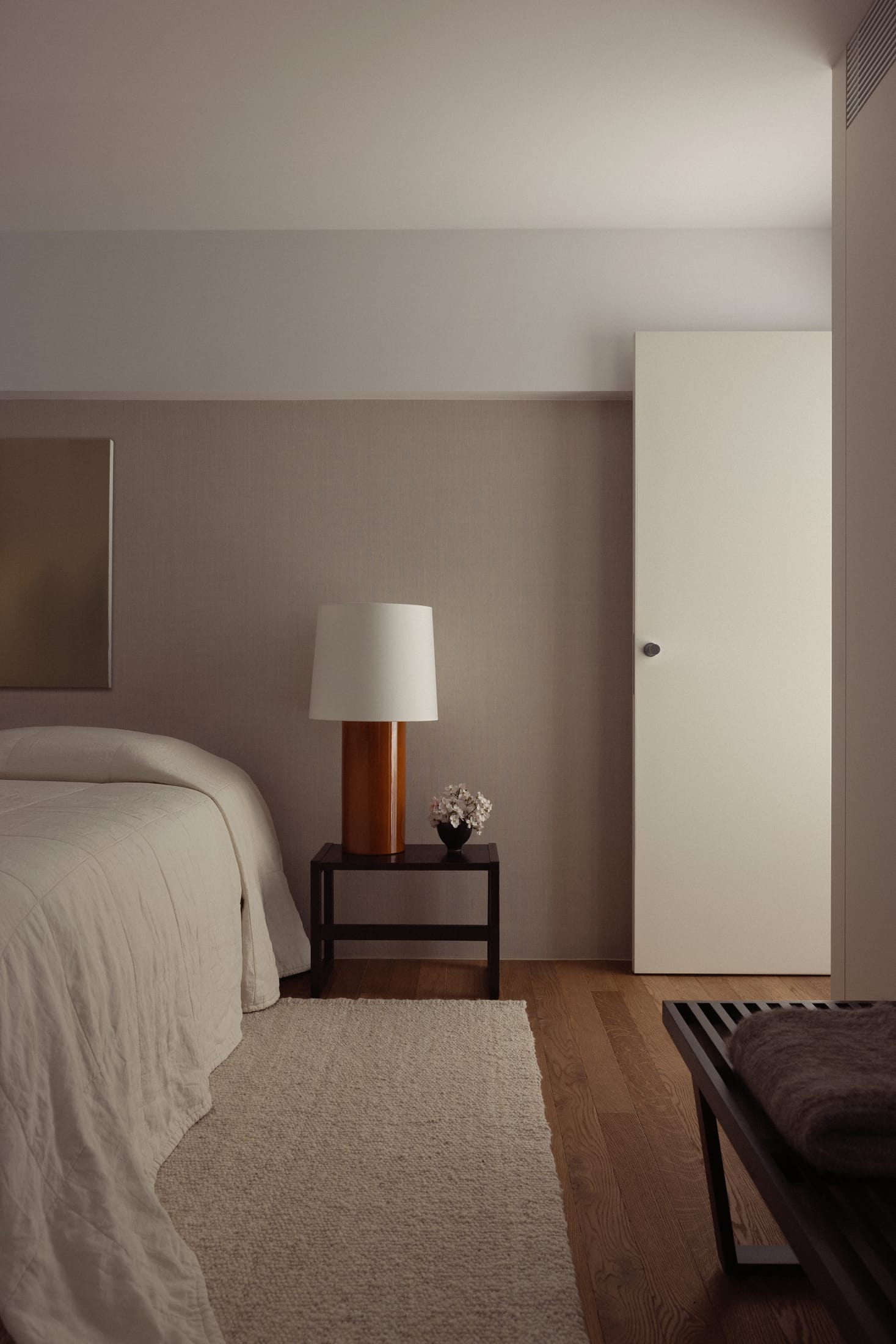 A view through a large window overlooking the coastal grass and sea from a minimalist interior.
