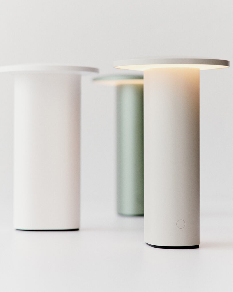 Three Solae portable lamps in white and green finishes displayed on a white surface.