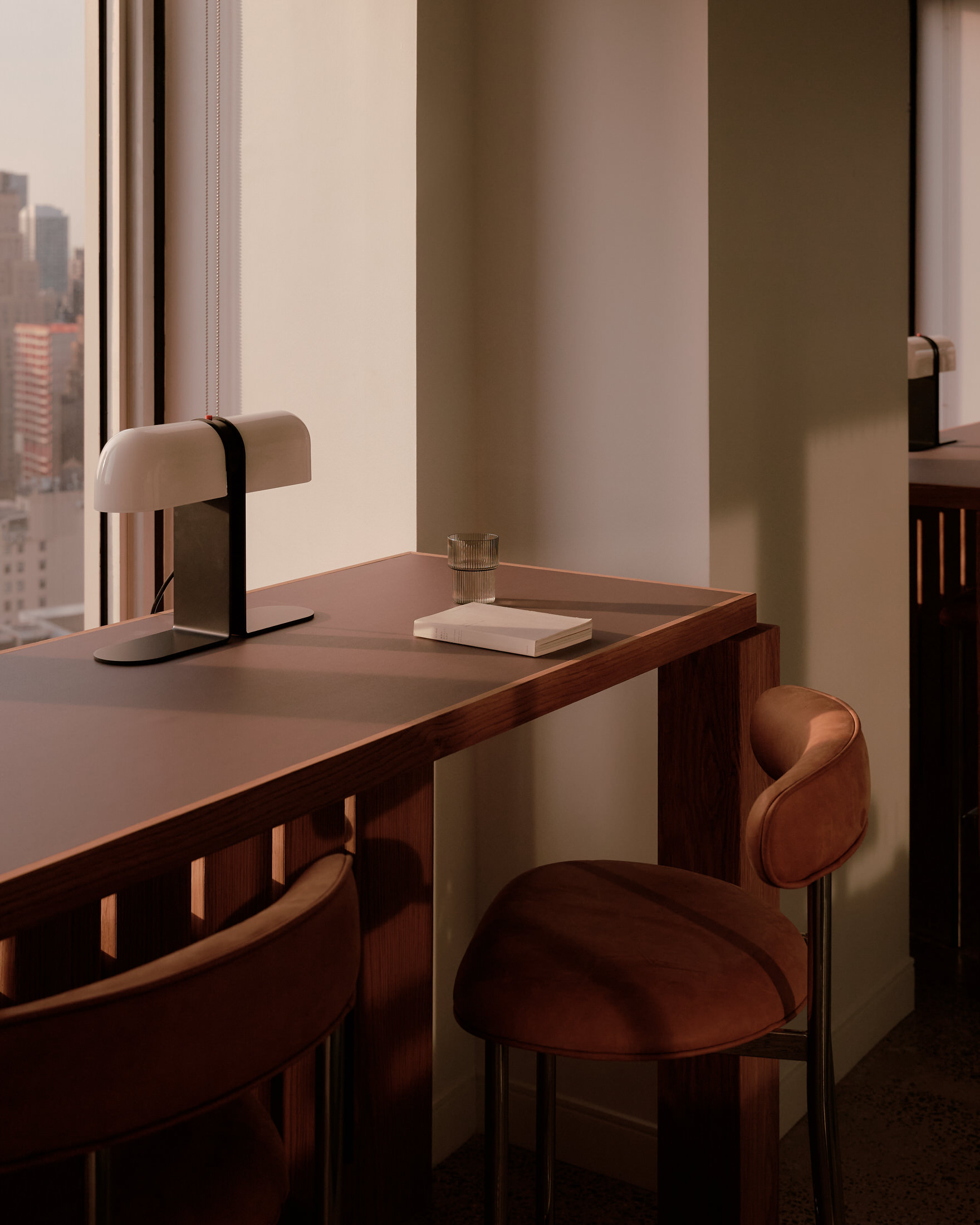 Detailed view of warm eucalyptus wood partitions meeting the grey concrete waffle ceiling.