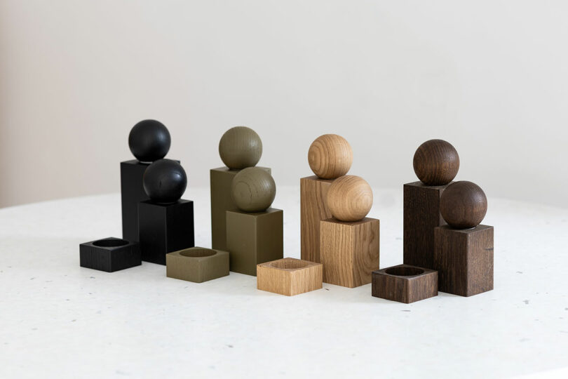 A row of TWIST salt and pepper grinders in black, olive green, smoked oak, and natural oak finishes.
