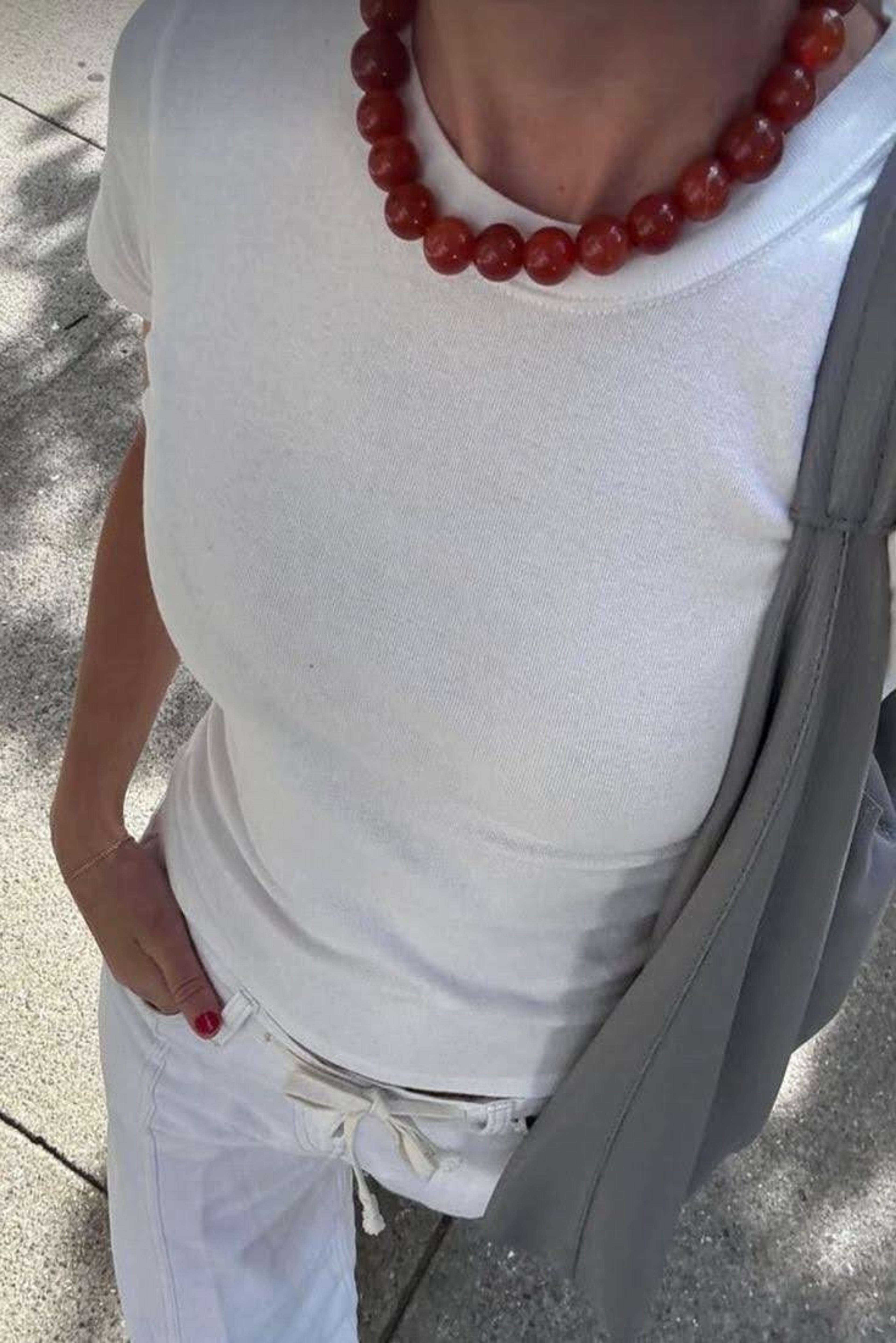 Close-up of a woman wearing a statement gold chunky necklace.