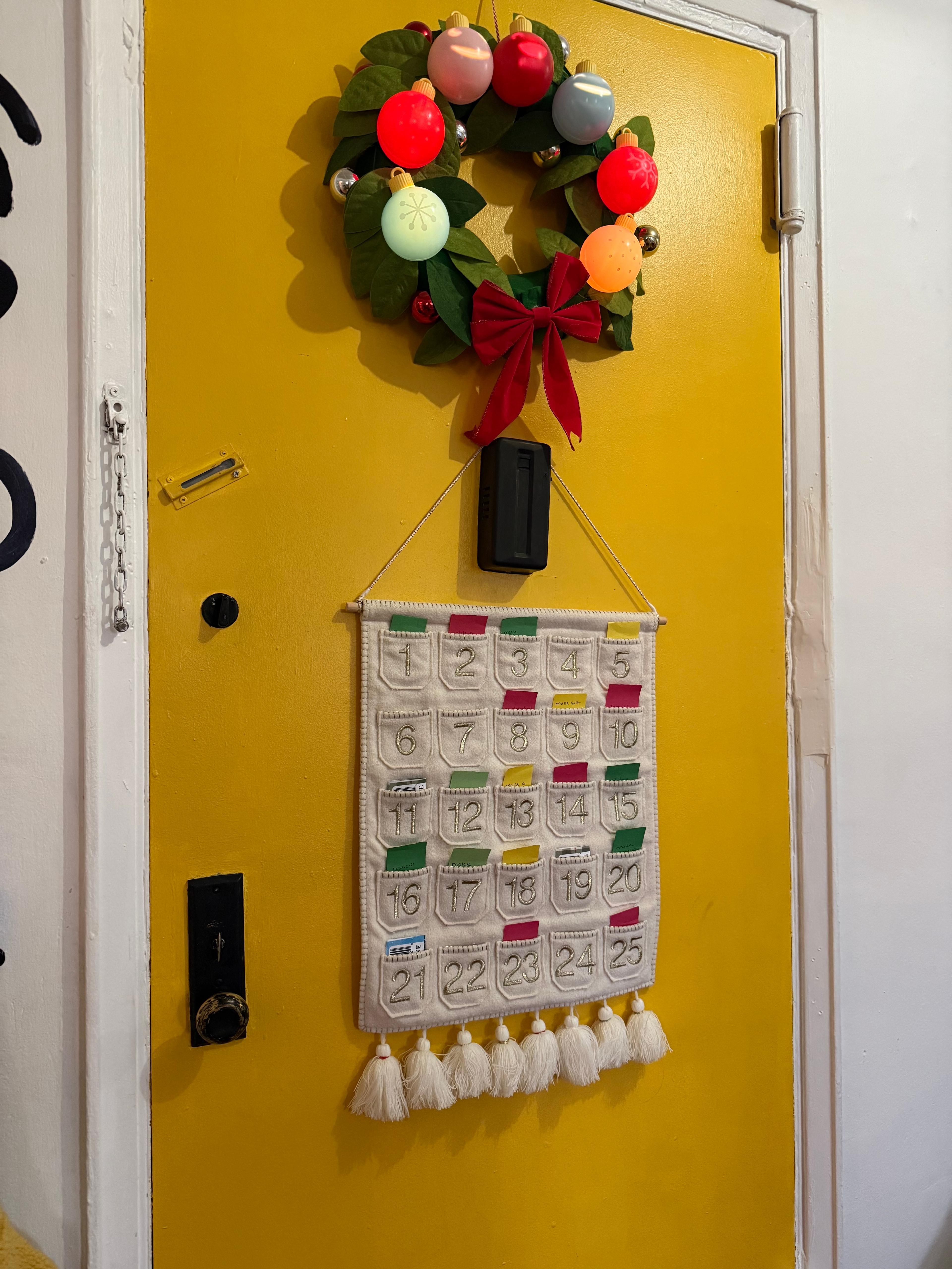 A DIY photo advent calendar hanging on a string with small wooden clips.