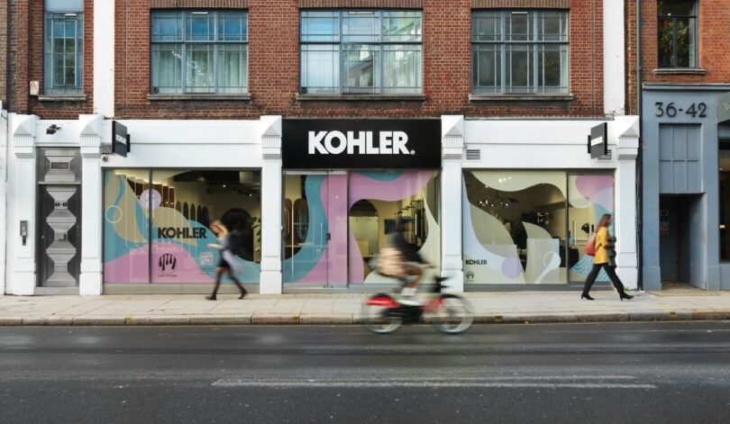 A Kohler storefront with brick architecture and vibrant window displays designed by Lois O'Hara.