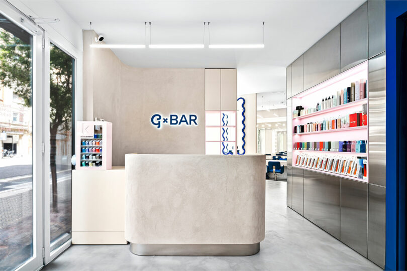 A bright and airy salon reception area with large windows and clean, modern product displays.