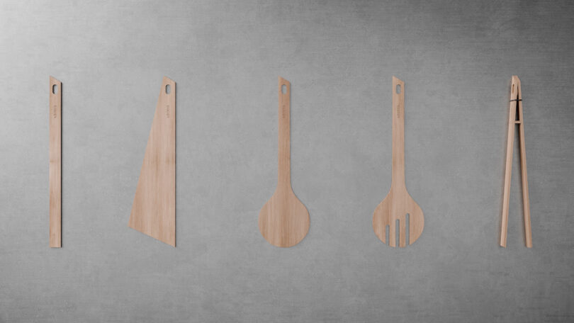 Five wooden kitchen utensils including tongs and spatulas arranged in a row.