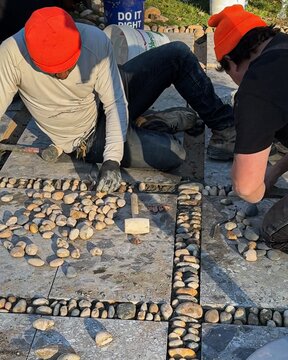 A stone garden pedestal set against a natural background, highlighting material texture.