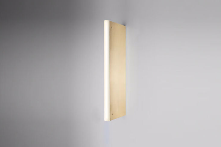 A high-end Michael Anastassiades Tube wall light featuring a satin brass finish.