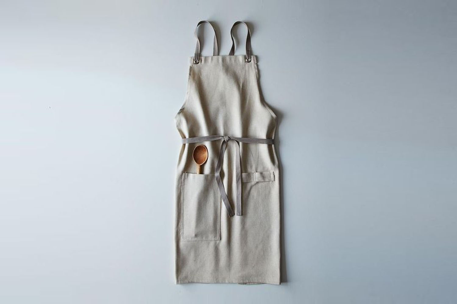 A folded linen kitchen apron in a deep indigo blue.