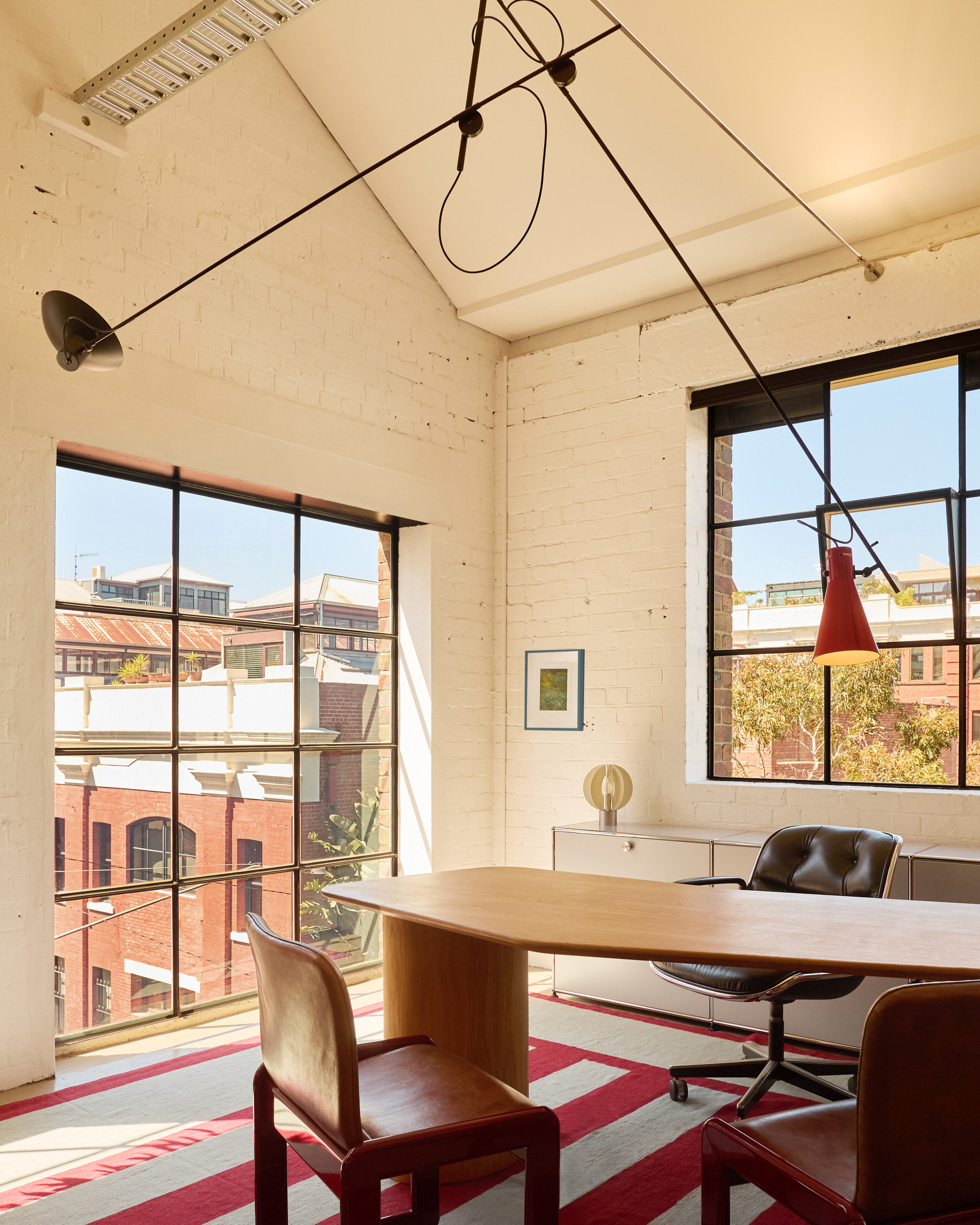 A large communal kitchen island in a modern office setting used for both prep and meetings.