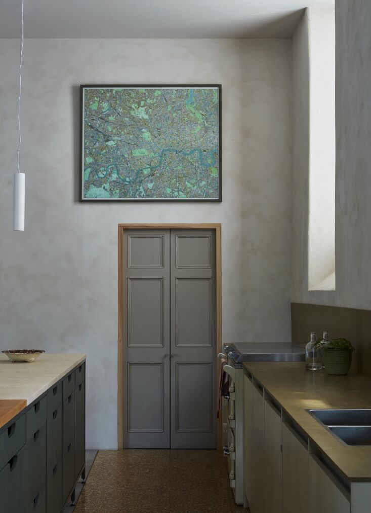 Detail of plywood kitchen drawers stained in a deep blue-green pigment.