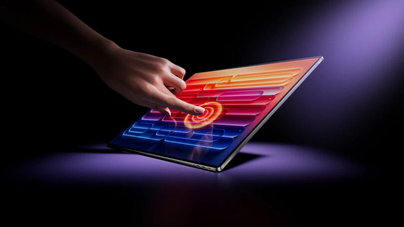 A close-up of a hand touching a vibrant, high-contrast OLED screen.