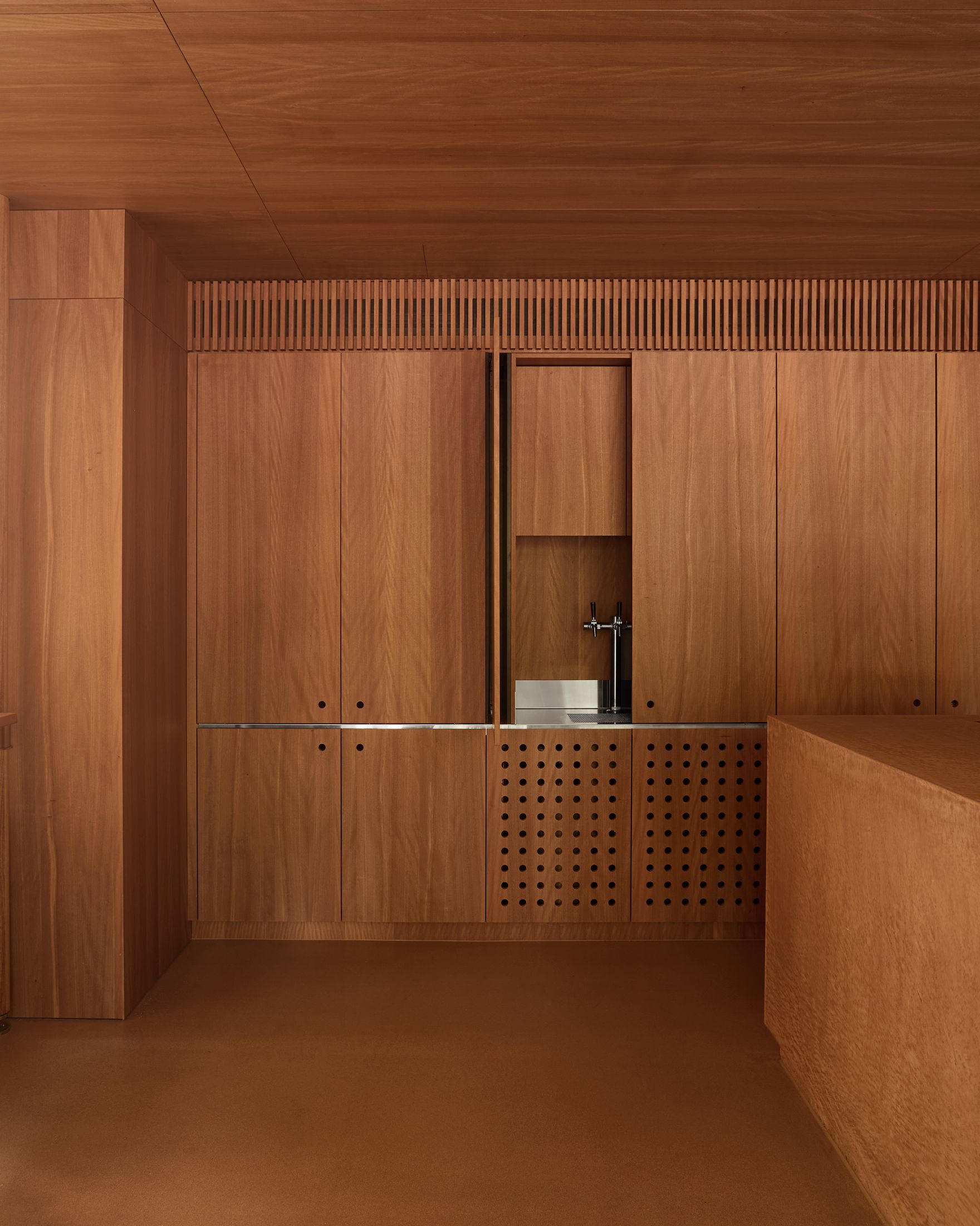 Vertical timber poles standing as structural and aesthetic anchors within the minimalist cafe space.