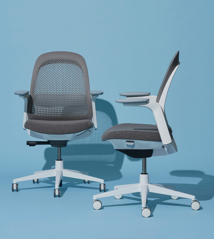 Two Haworth Breck chairs in a light gray and white color scheme against a blue background.