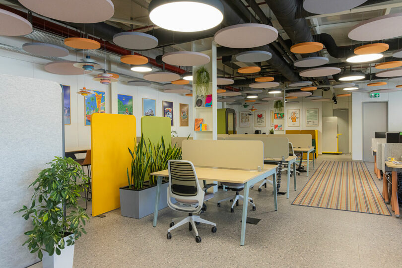 Close-up of colorful acoustic panels hanging from the ceiling in an open-plan office.