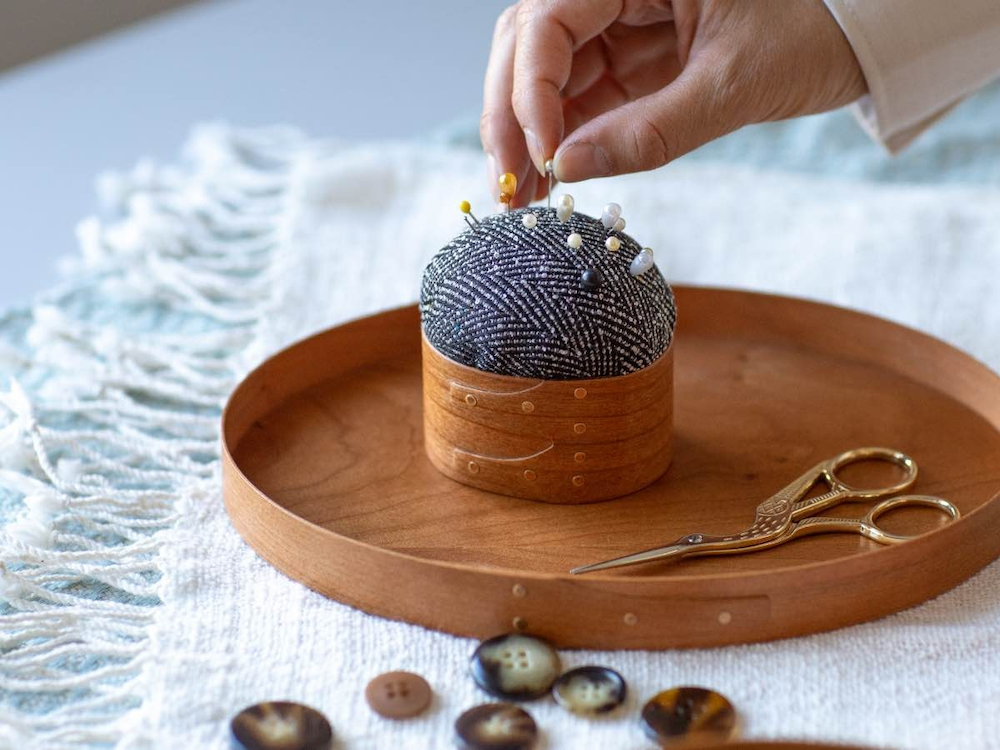 A Shaker-style wooden tray featuring a matching fabric pin cushion.