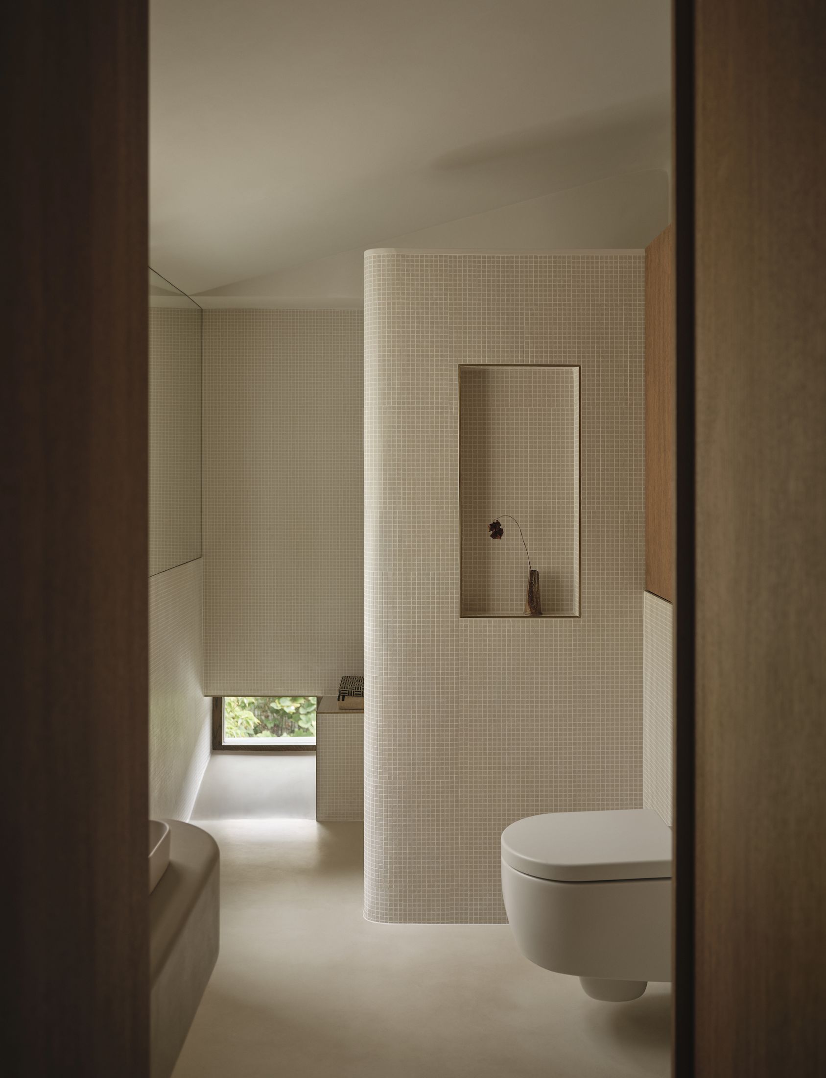 A modern Japanese-style Genkan entryway with textured glass panels and smoked oak accents.