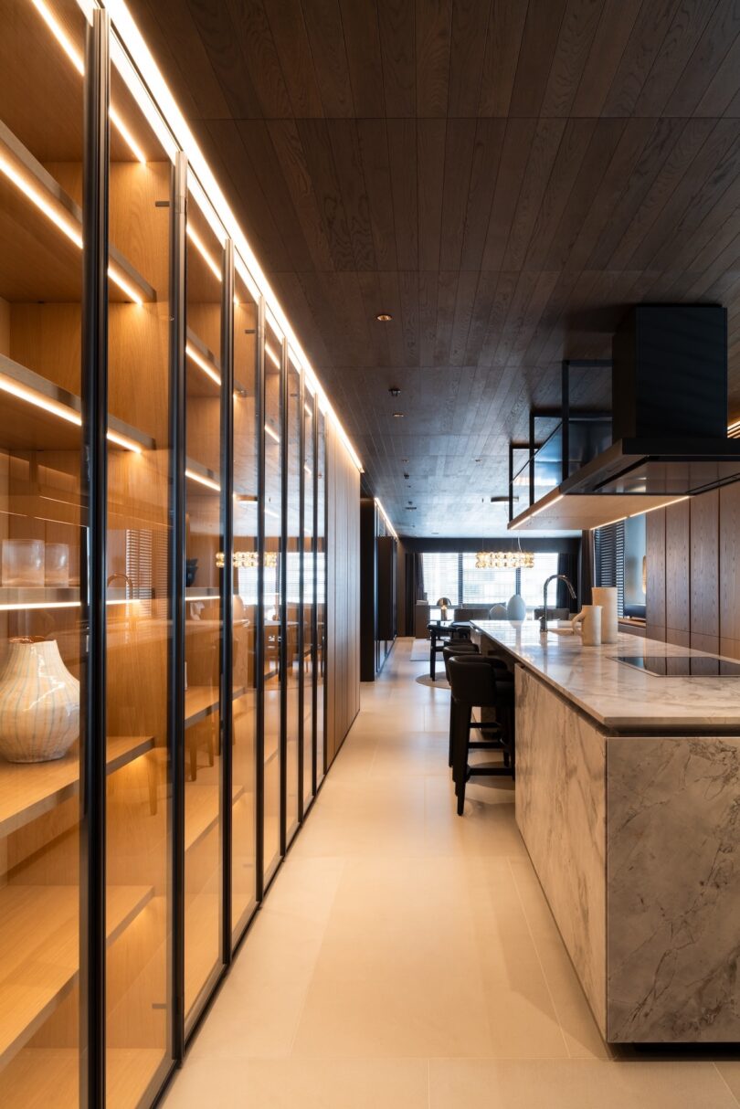 Minimalist kitchen with glass-fronted Molteni cabinets and integrated LED lighting.