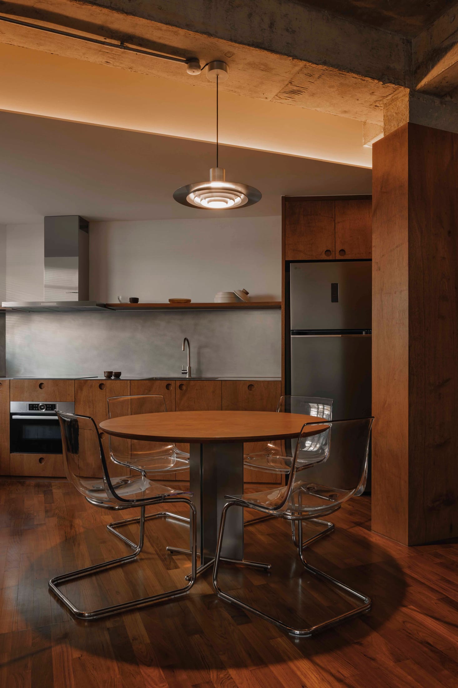 A clean, minimalist kitchen area with hidden cabinetry and integrated appliances.