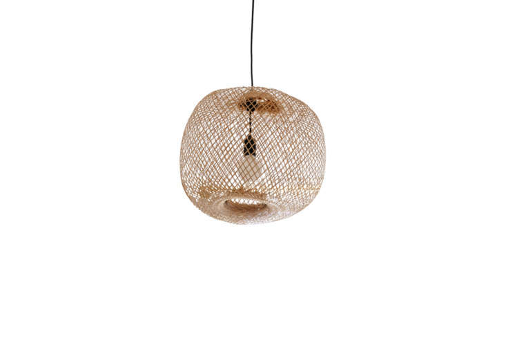 A round bamboo pendant light hanging from a high ceiling.