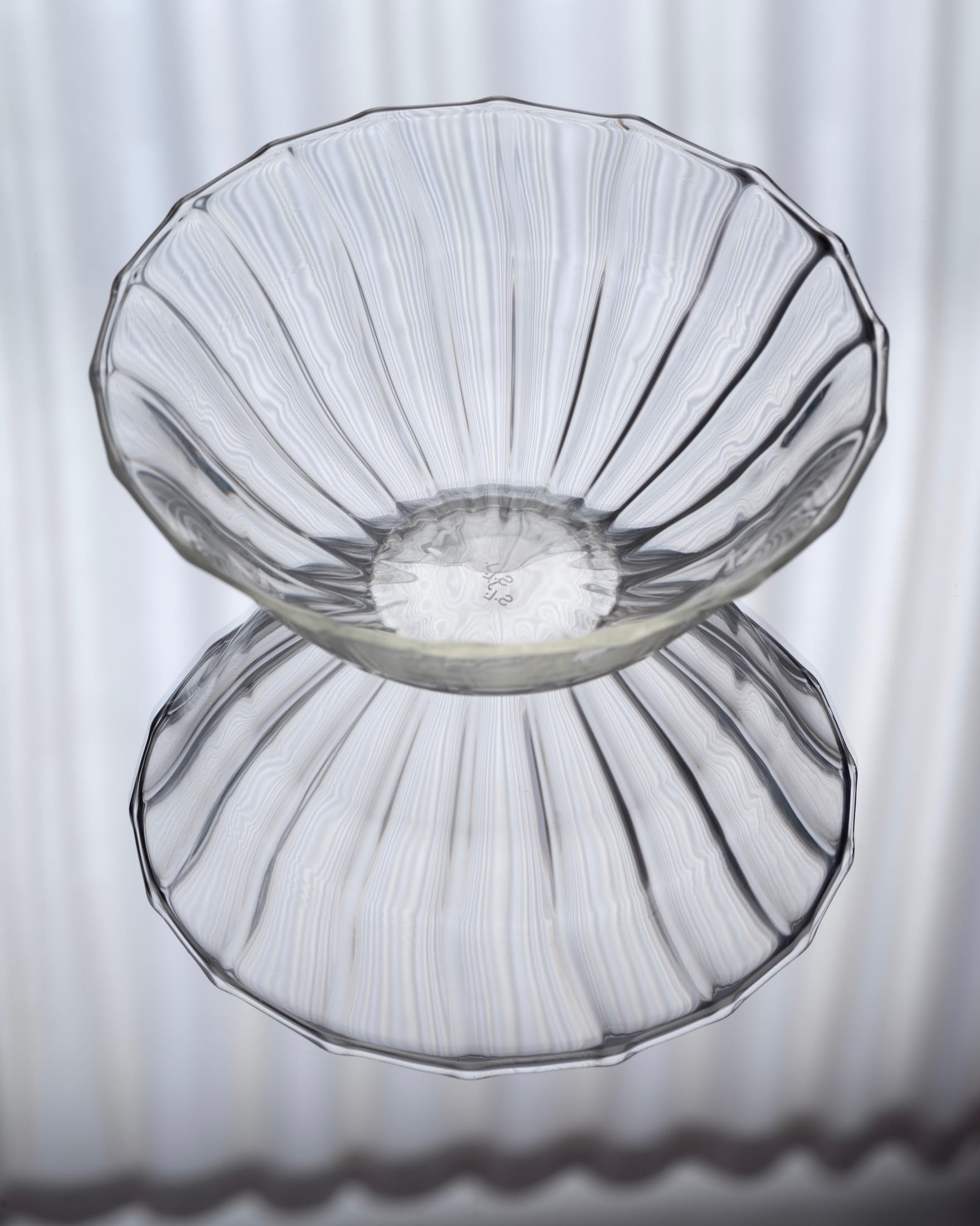 Close-up of a small rippled glass bowl in a soft yellow hue with organic edges.