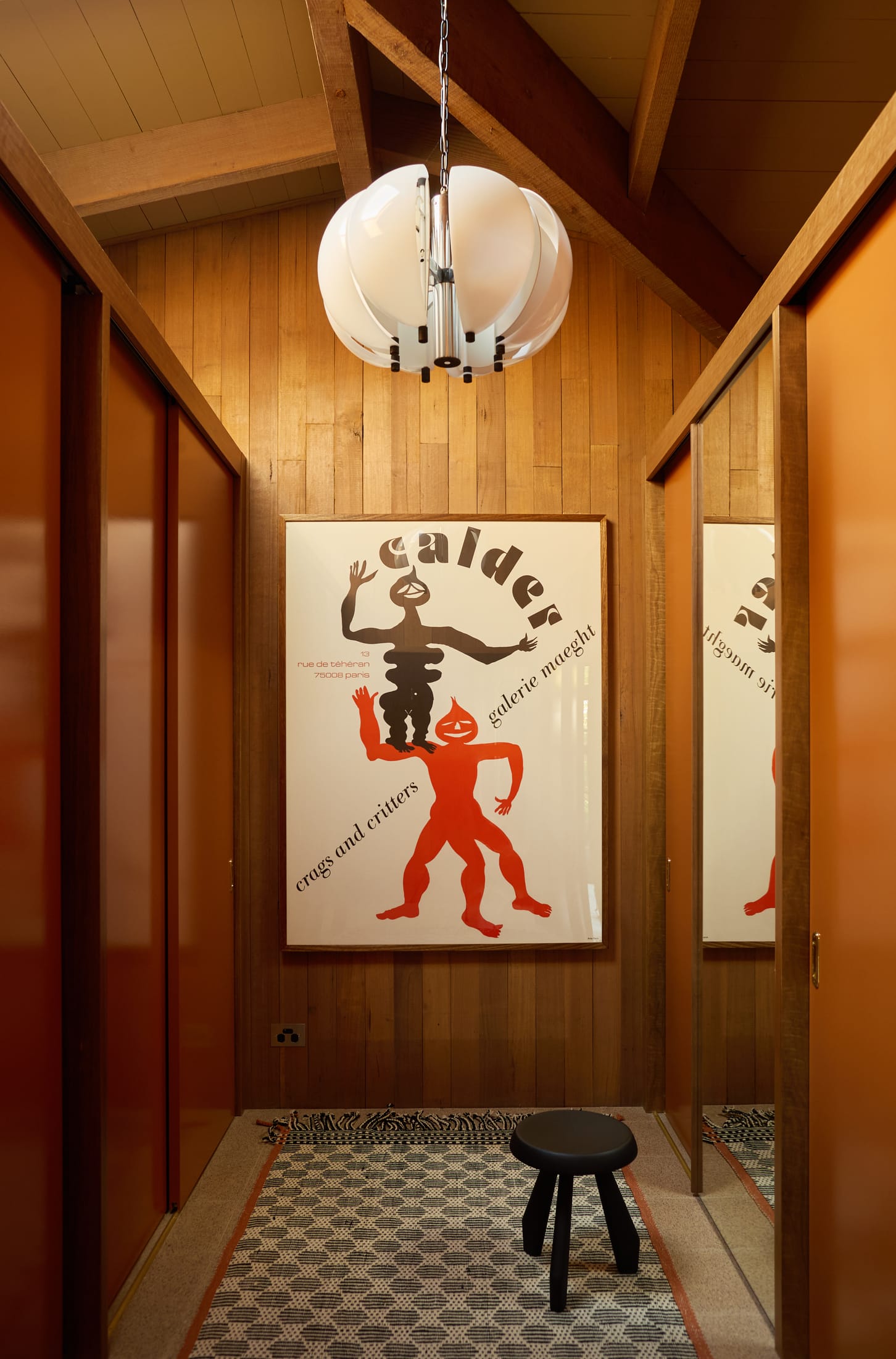 A bedroom corner featuring a sculptural modern lamp and textured linens.