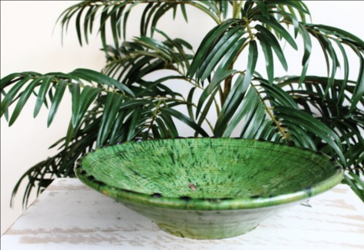 A rustic Tamegroute green pottery bowl with visible glaze imperfections.