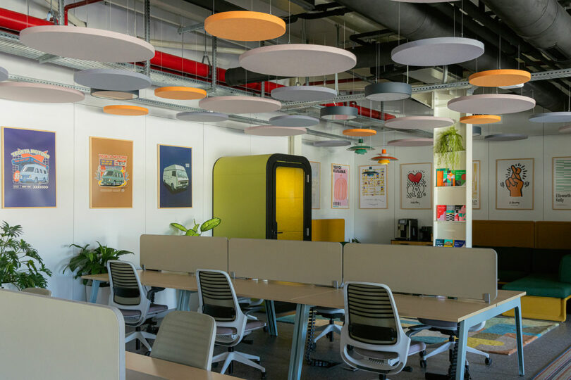 Overview of the Tegeta office space with colorful circular ceiling panels and modern workstations.